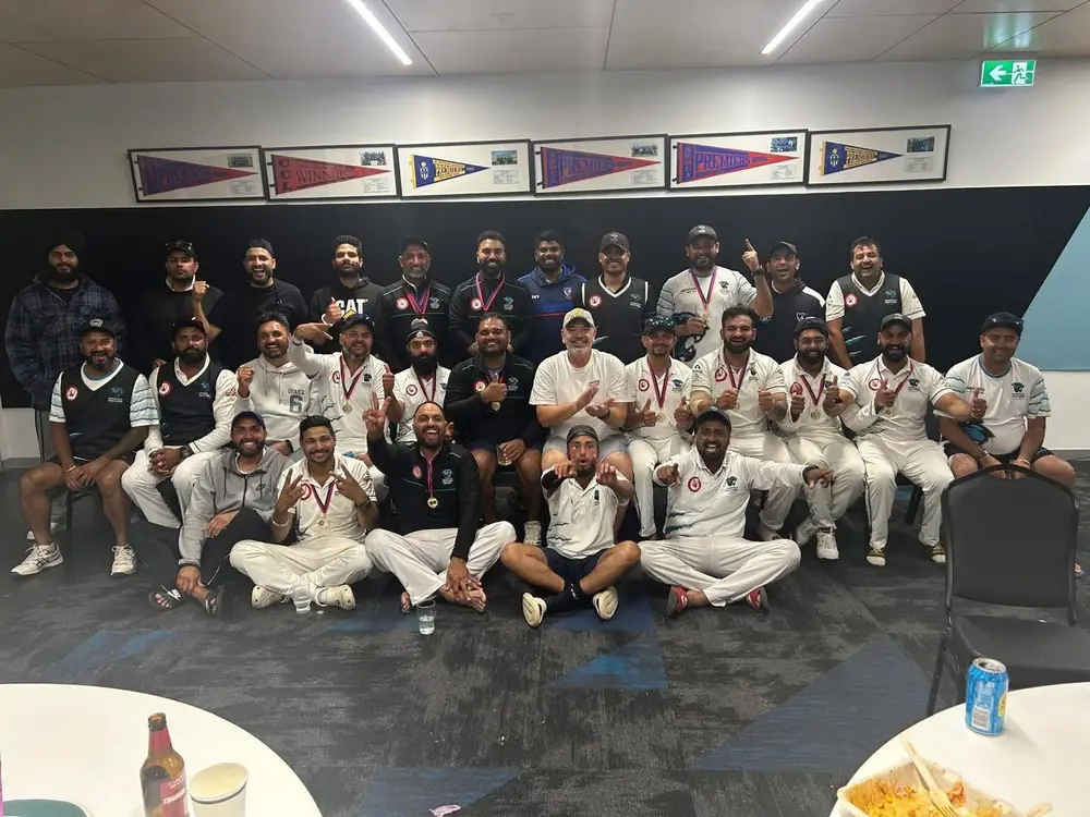 Merrifield Panthers players celebrating with medals in the rooms, under the club's premiership pennants